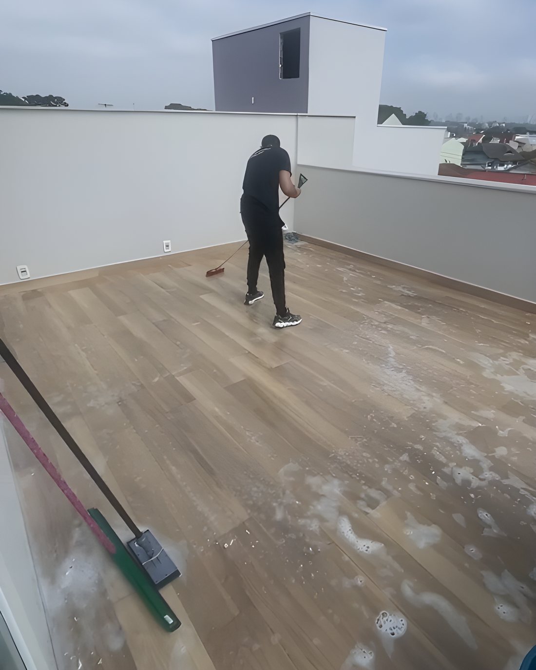 Profissional lavando o piso de um terraço depois da obra